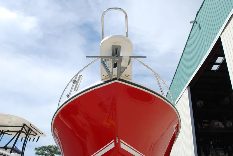 Slide: The Image of 1996 Regulator 26 Classic boat with a red hull, docked near a green building. - 7