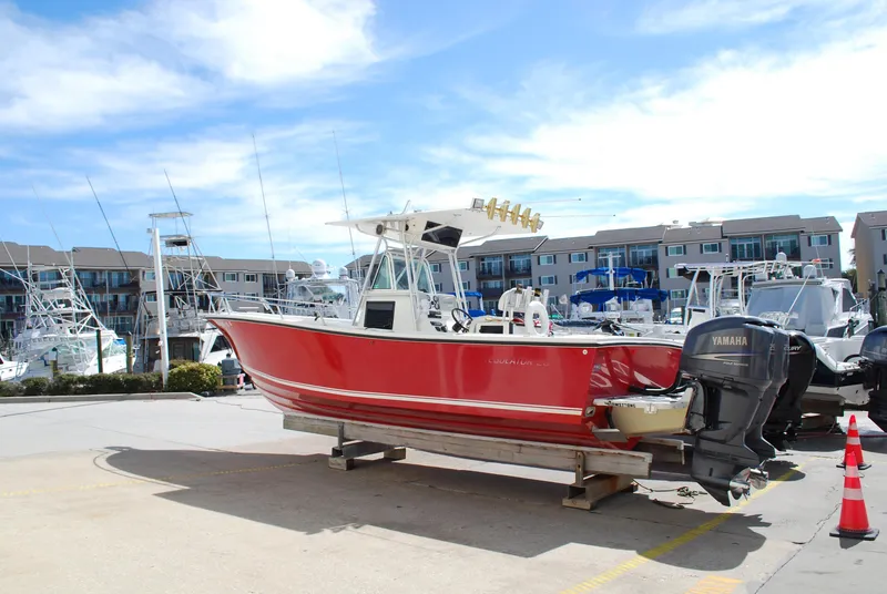Slide: The Image of 1996 Regulator 26 Classic boat with red hull on a dock, Yamaha outboard engines. - 9