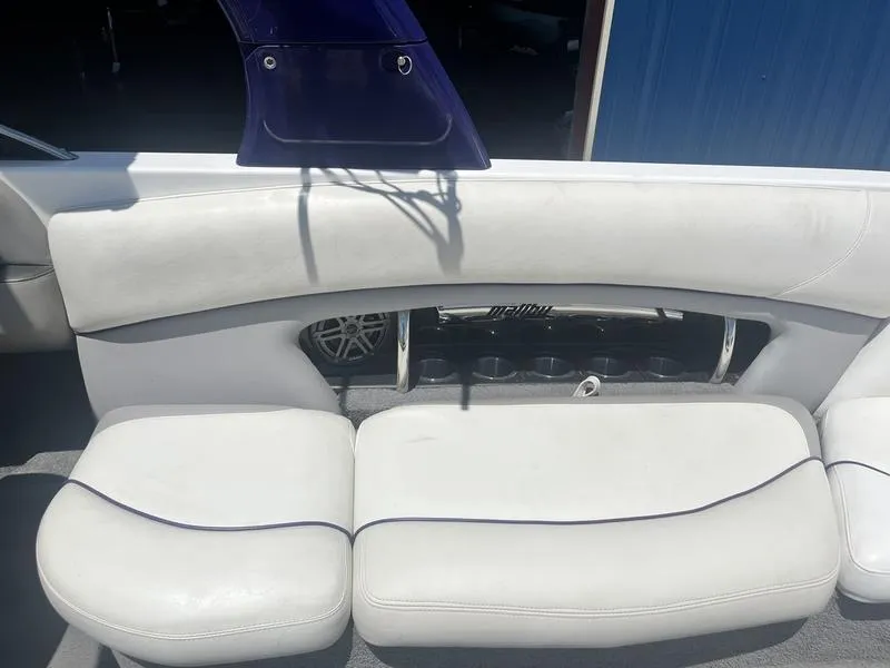 Slide: The Image of 2007 Malibu 247 LSV boat interior with white cushioned seating. - 12