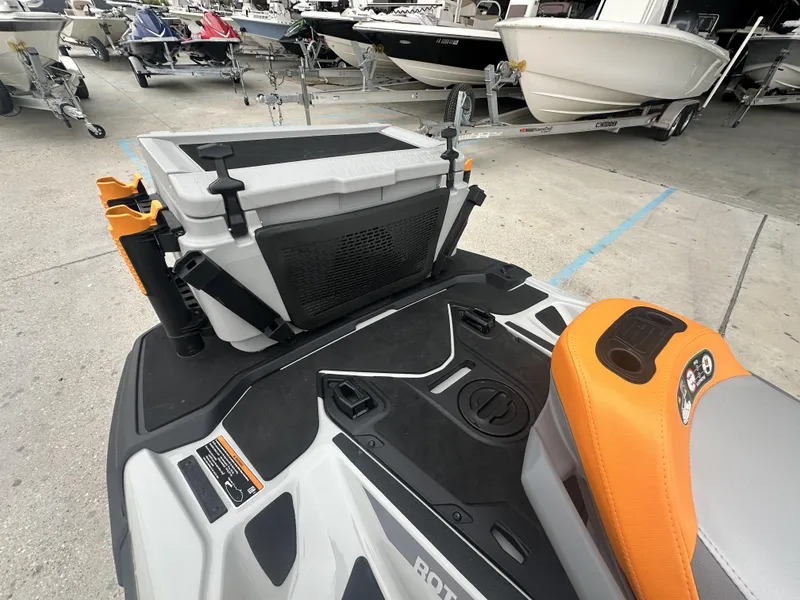 Slide: The Image of 2023 Sea-Doo Fish/Pro jet ski with cooler and fishing rod holders, docked near boats. - 6