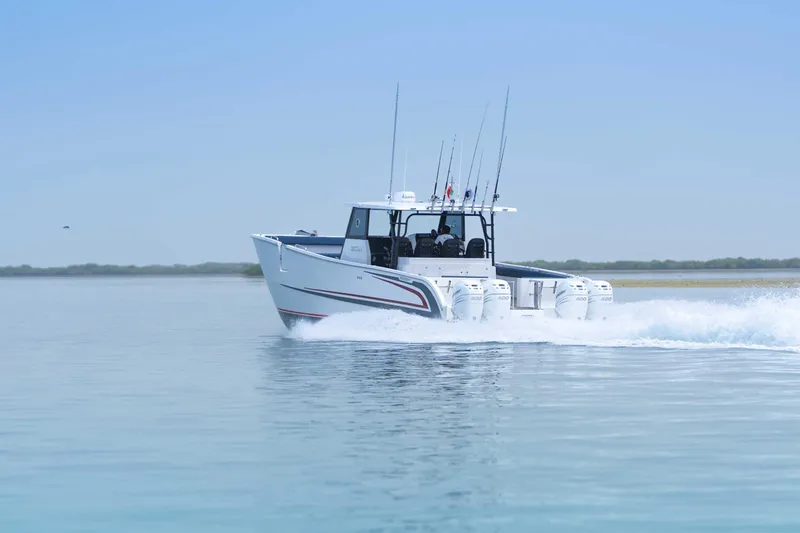 Slide: The Image of Custom SilverCAT 40CC 2025 boat cruising on calm water with fishing rods. - 32