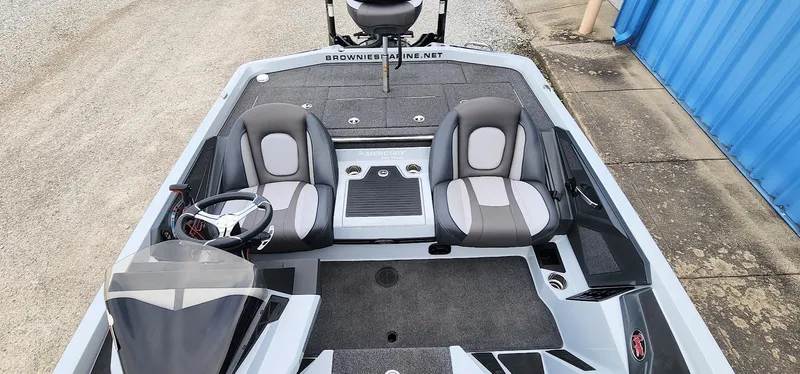 Slide: The Image of 2022 Ranger Z519 boat interior with dual seats and steering wheel, parked near blue building. - 6