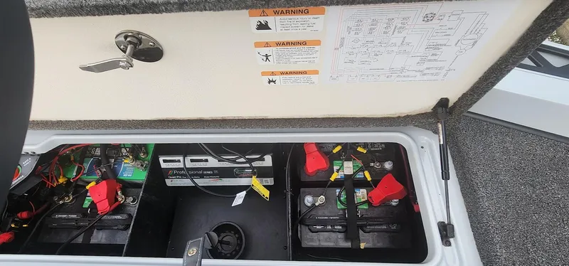 Slide: The Image of 2022 Ranger Z519 boat battery compartment with wiring and warning labels. - 9