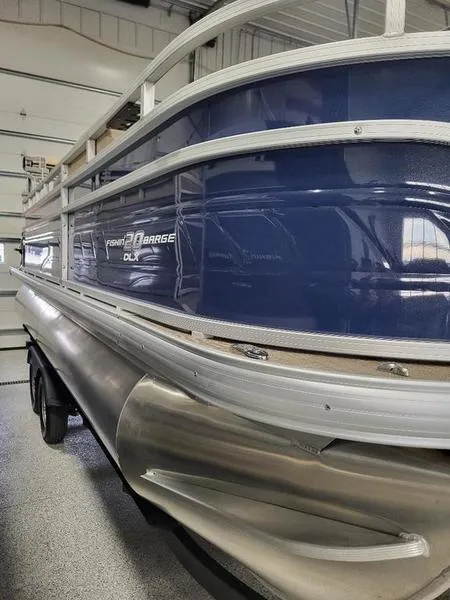 Slide: The Image of 2024 Sun Tracker Fishin Barge 20 DLX pontoon boat in a garage. - 2