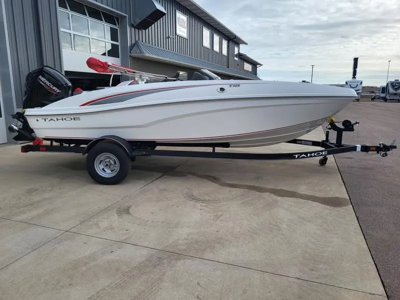 Slide: The Image of 2024 Tahoe T18 boat on trailer outside a building. - 0