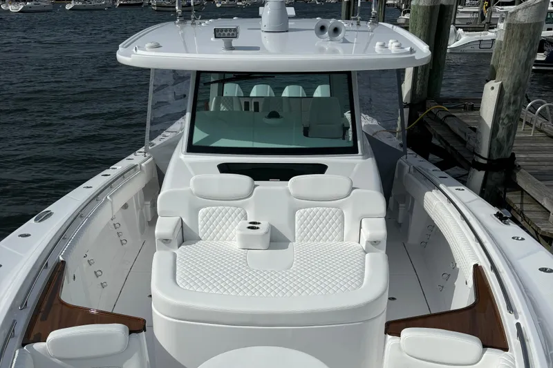 Slide: The Image of HCB 48 CAMPEON 2025 luxury boat with white seating and docked at marina. - 11