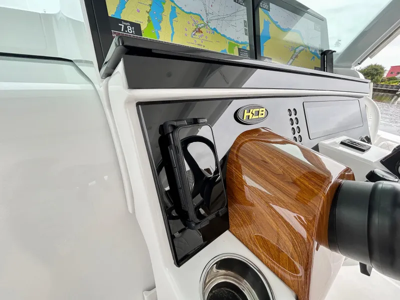 Slide: The Image of 2025 HCB 48 Campeon boat dashboard with navigation screens and wooden steering wheel. - 36