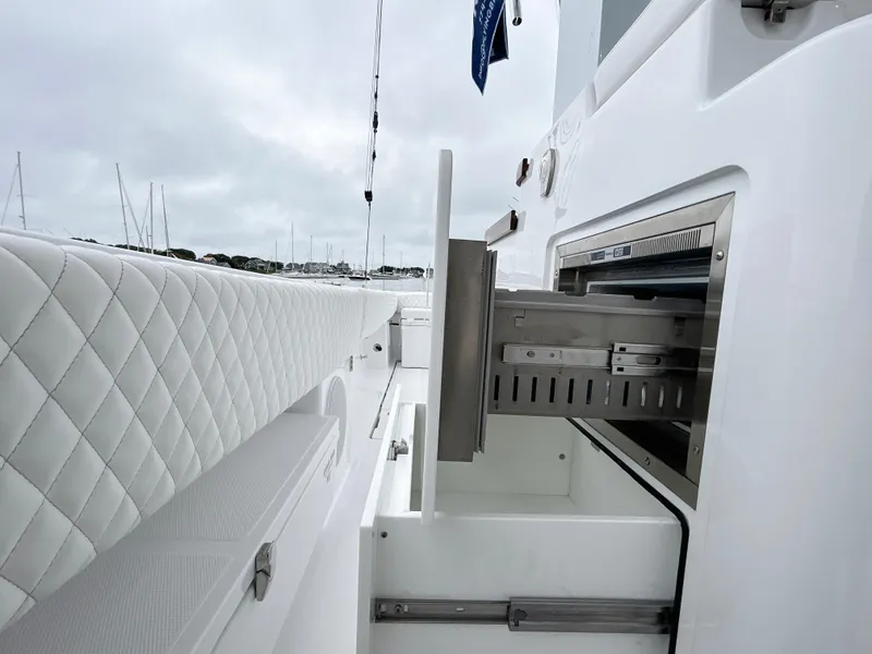 Slide: The Image of 2025 HCB 48 Campeon boat interior with white quilted seating and storage compartment. - 39