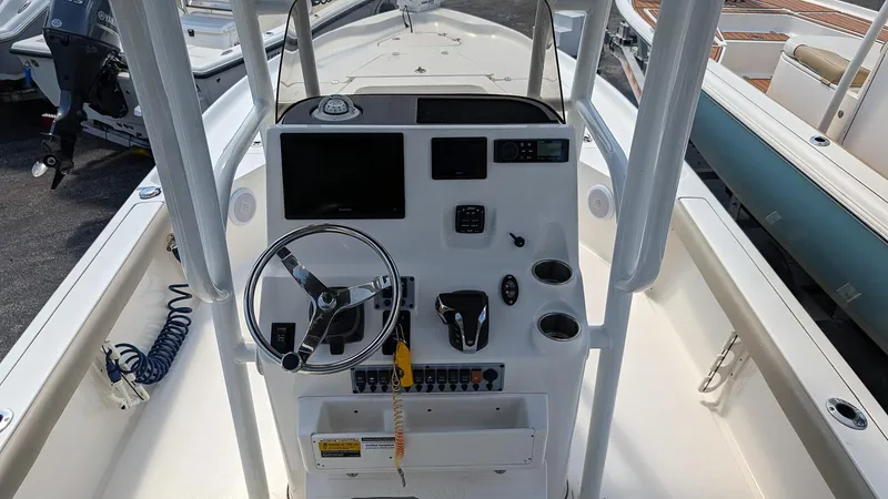 Slide: The Image of 2023 Key West 250 Bay Reef boat console with steering wheel and electronic controls. - 10