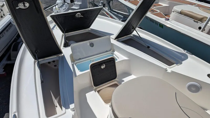 Slide: The Image of 2023 Key West 250 Bay Reef boat with open storage compartments and seating. - 17
