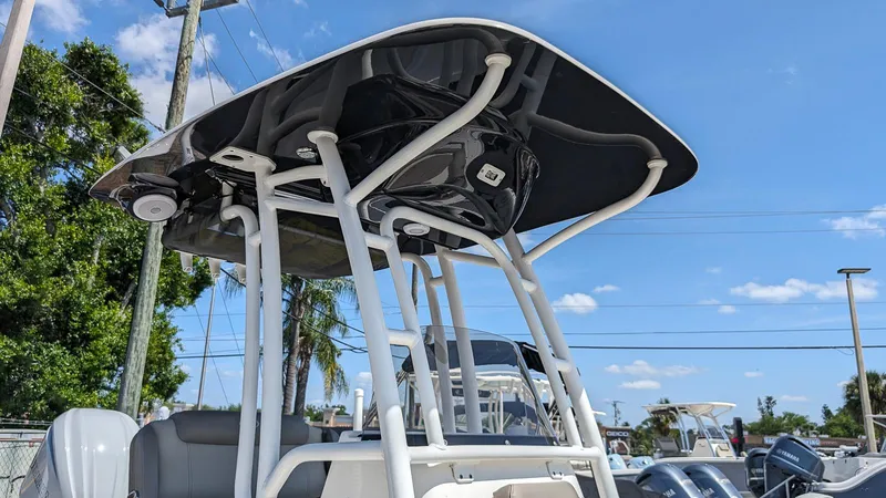 Slide: The Image of 2023 Key West 250 Bay Reef boat with T-top under a clear blue sky. - 19