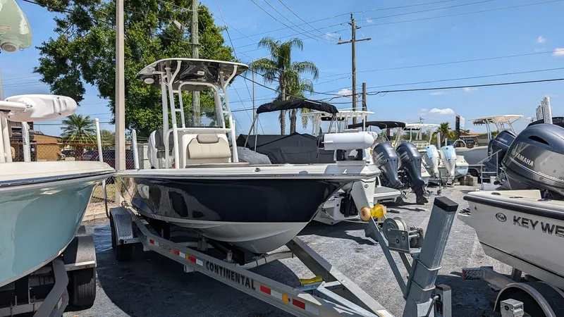 Slide: The Image of 2023 Key West 250 Bay Reef boat on a trailer in a marina. - 2