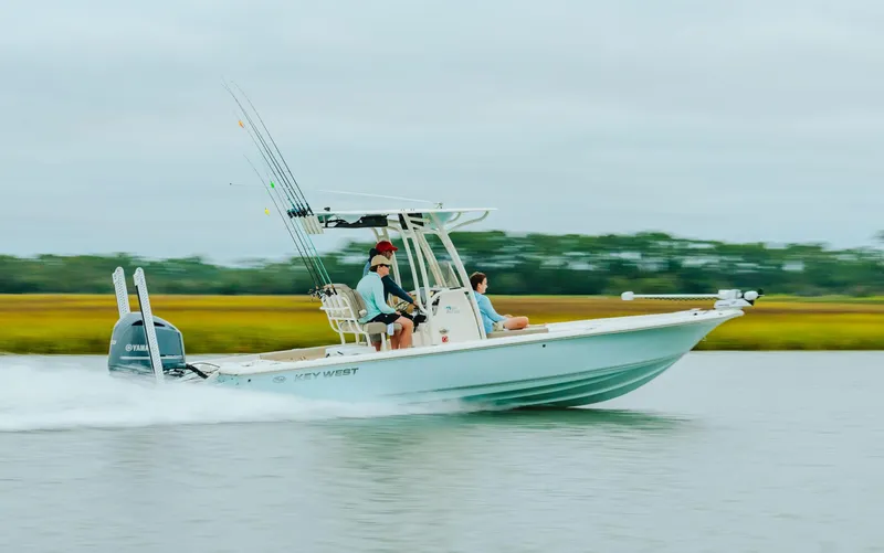 Slide: The Image of 2023 Key West 250 Bay Reef boat speeding on water with two passengers. - 21
