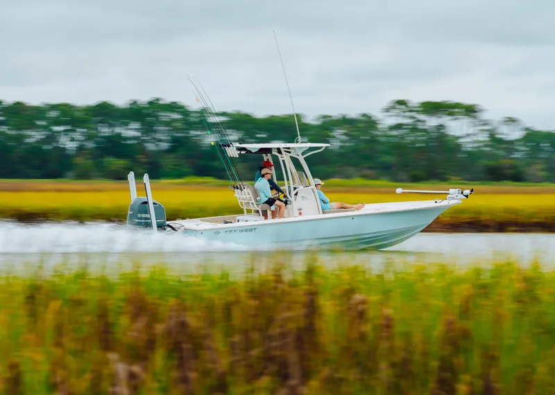Slide: The Image of 2023 Key West 250 Bay Reef boat speeding through water with anglers. - 31