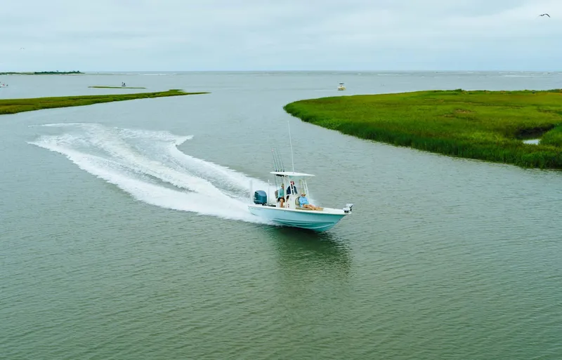 Slide: The Image of 2023 Key West 250 Bay Reef boat cruising in a serene waterway. - 35