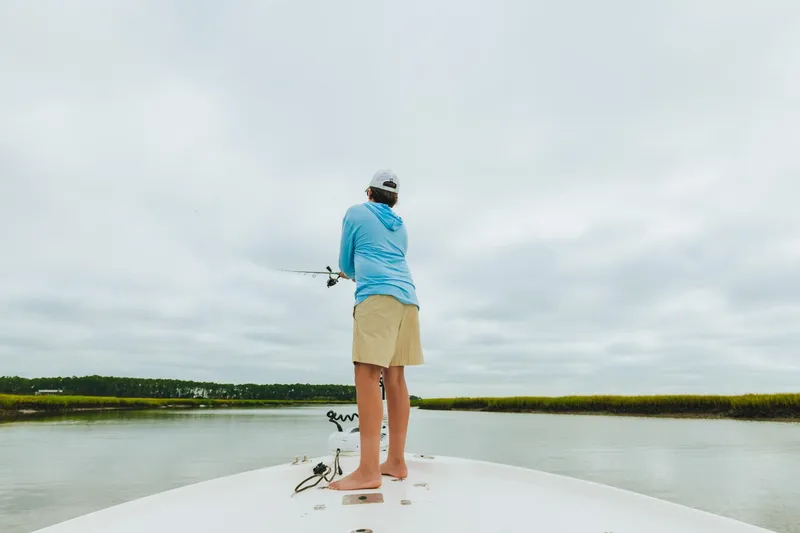 Slide: The Image of Person fishing on a 2023 Key West 250 Bay Reef boat in a calm waterway. - 36