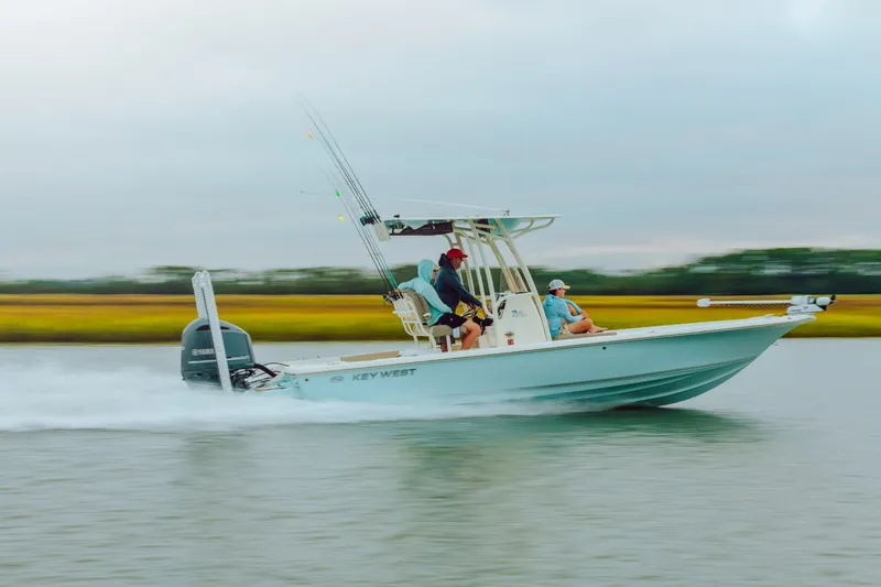 Slide: The Image of 2023 Key West 250 Bay Reef boat speeding on water with two passengers. - 43