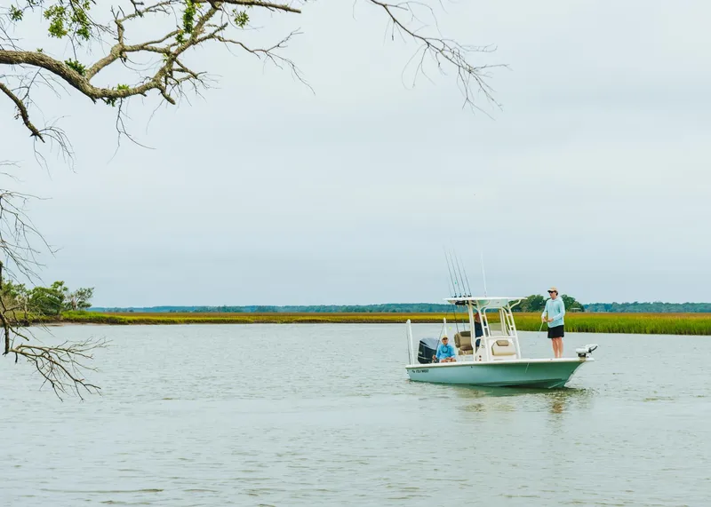 Slide: The Image of 2023 Key West 250 Bay Reef boat on a calm lake with anglers fishing. - 46