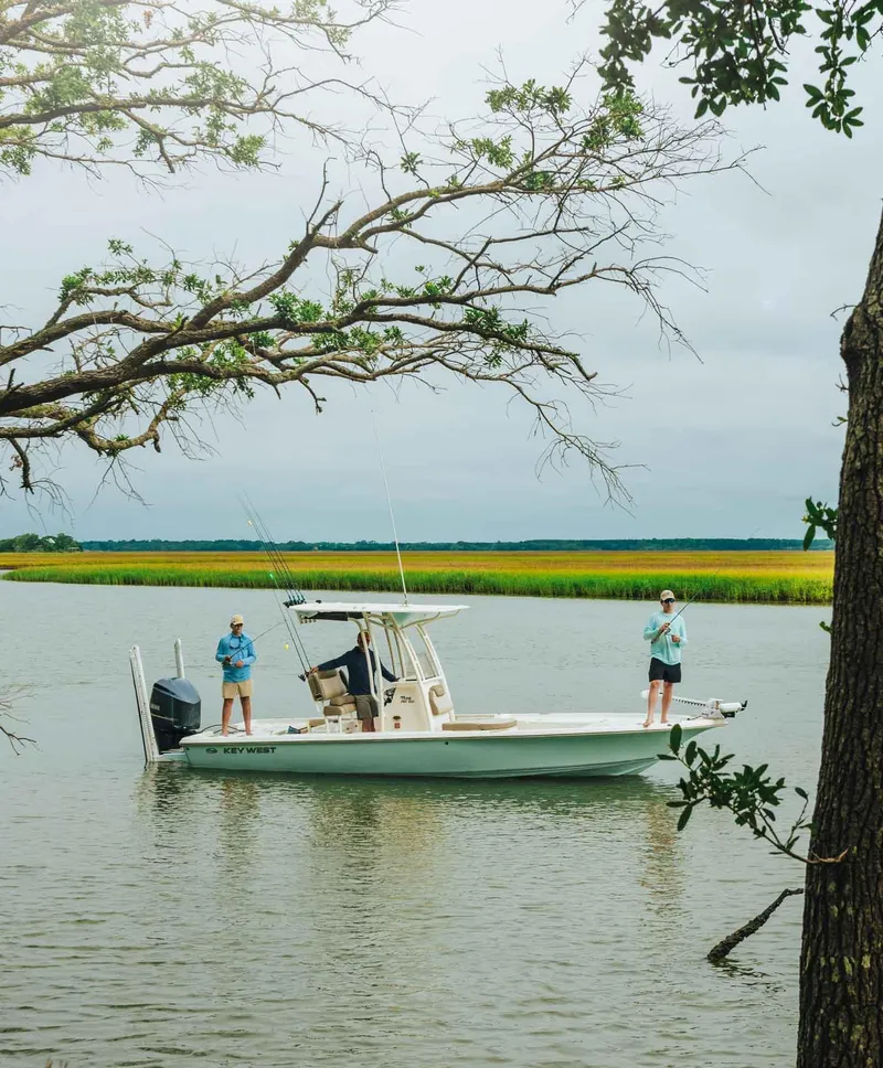 Slide: The Image of 2023 Key West 250 Bay Reef boat on a serene lake with two people fishing. - 49