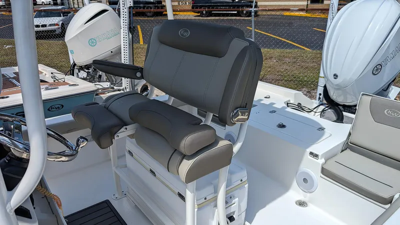 Slide: The Image of 2023 Key West 250 Bay Reef boat interior with cushioned seating and dual outboard motors. - 9