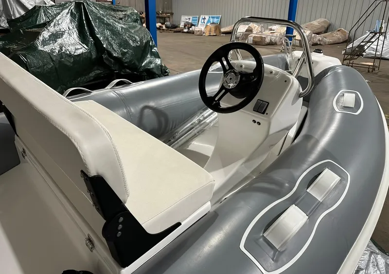 Slide: The Image of 2024 Apex A-10 Eurosport Rib Gallery boat interior with steering wheel and seating. - 4