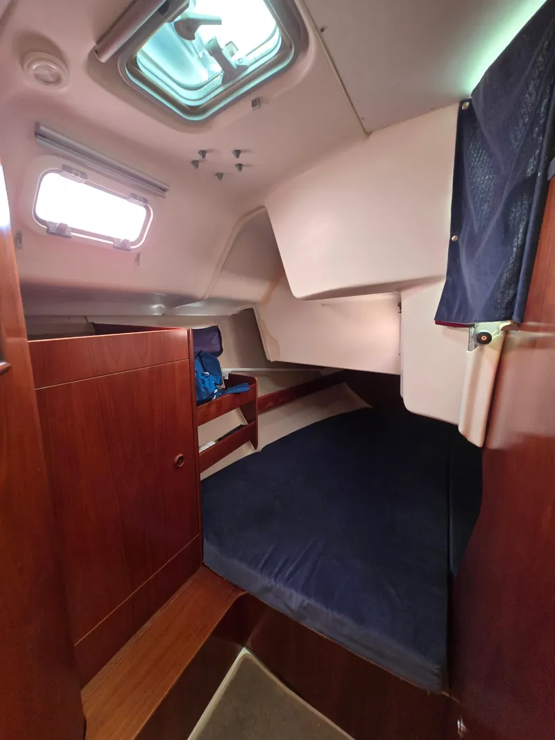 Slide: The Image of Interior cabin of 1995 Beneteau Oceanis 351 sailboat with wooden finish and blue bedding. - 13