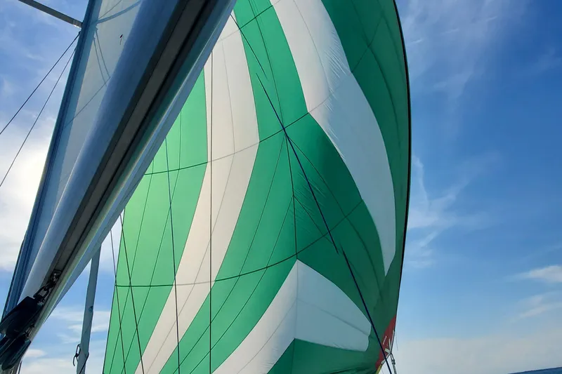 Slide: The Image of Green and white sail of a 1995 Beneteau Oceanis 351 against a clear blue sky. - 19