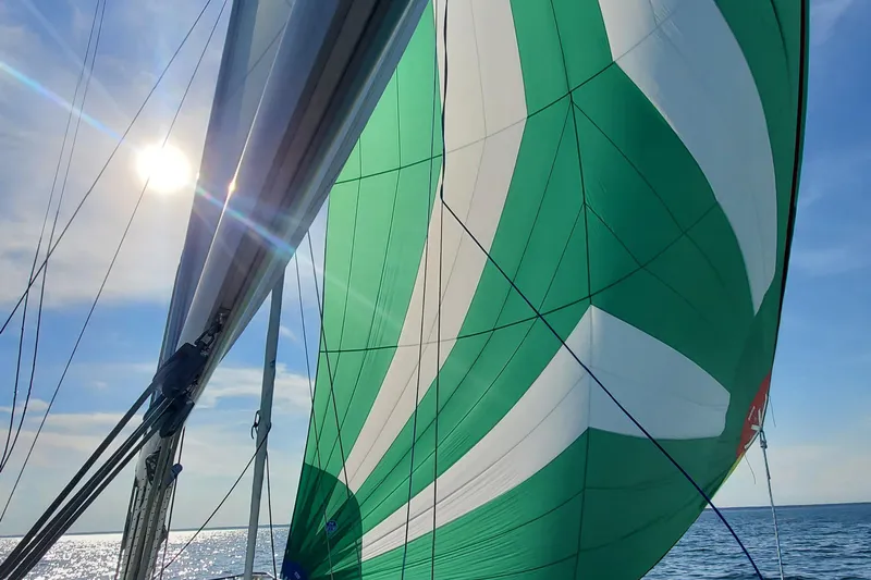 Slide: The Image of Sailing on a 1995 Beneteau Oceanis 351 with green and white spinnaker under sunny skies. - 20