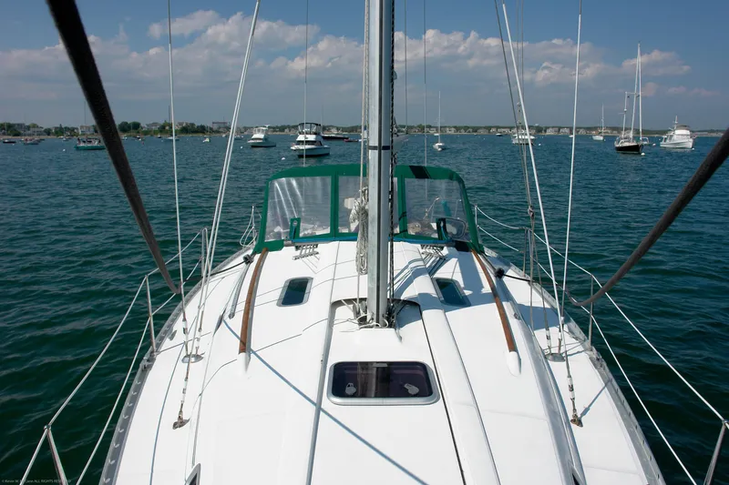 Slide: The Image of 1995 Beneteau Oceanis 351 sailboat on calm water, clear sky, and distant boats. - 21