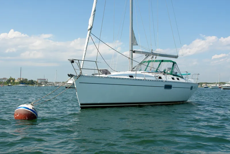 Slide: The Image of 1995 Beneteau Oceanis 351 sailboat anchored on calm water under a clear blue sky. - 32