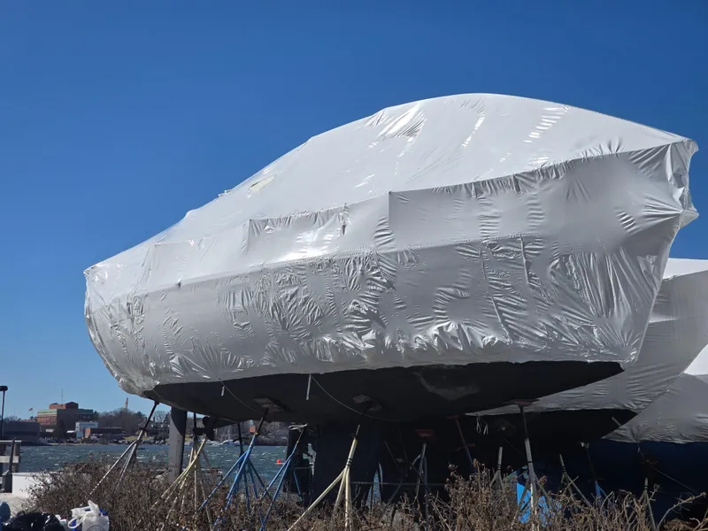 Slide: The Image of 1995 Beneteau Oceanis 351 sailboat covered in protective wrap, docked by the waterfront. - 38