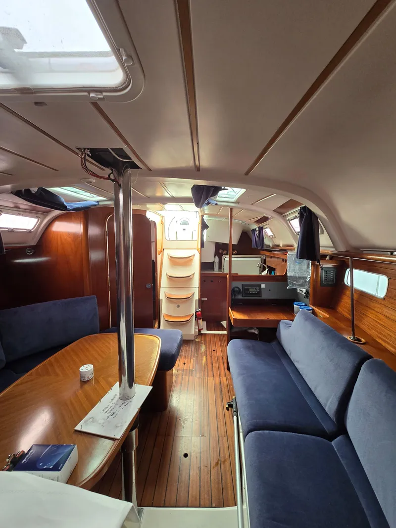 Slide: The Image of Interior of 1995 Beneteau Oceanis 351 sailboat with wooden finish and blue seating. - 5