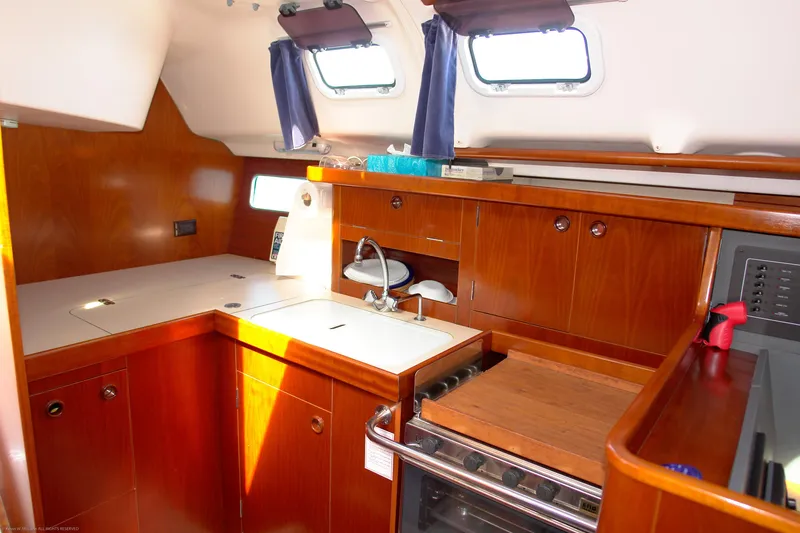Slide: The Image of 1995 Beneteau Oceanis 351 yacht interior kitchen with wood cabinetry and modern appliances. - 8