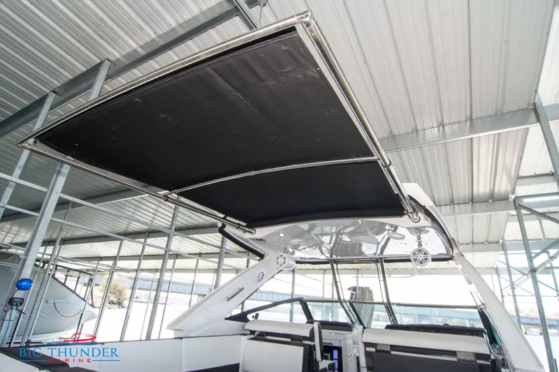 Slide: The Image of 2022 Monterey 378 SS boat with extended sunshade under a metal canopy. - 28
