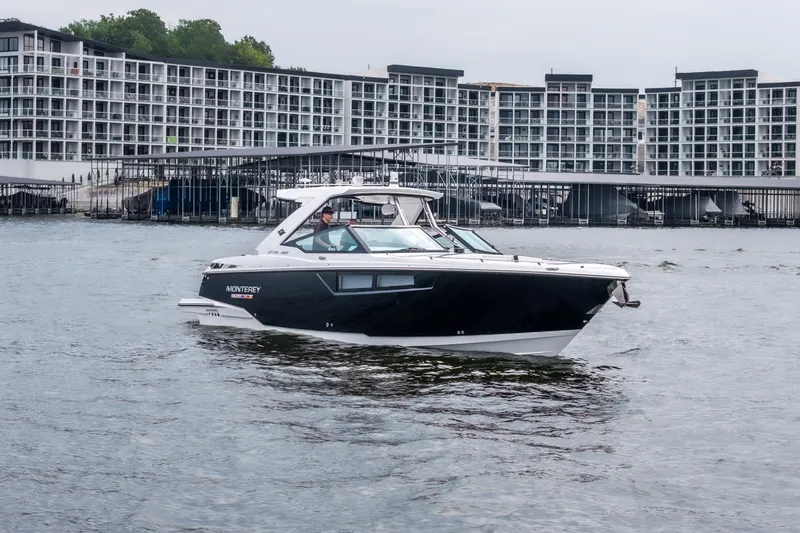 Slide: The Image of 2022 Monterey 378SS Super Sport boat cruising near modern waterfront buildings. - 2
