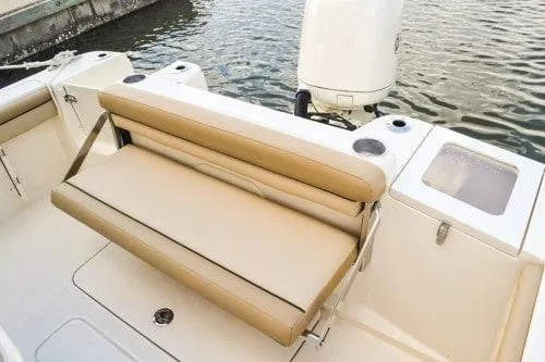 Slide: The Image of 2024 Scout 215XSF boat with tan seating and outboard motor. - 6