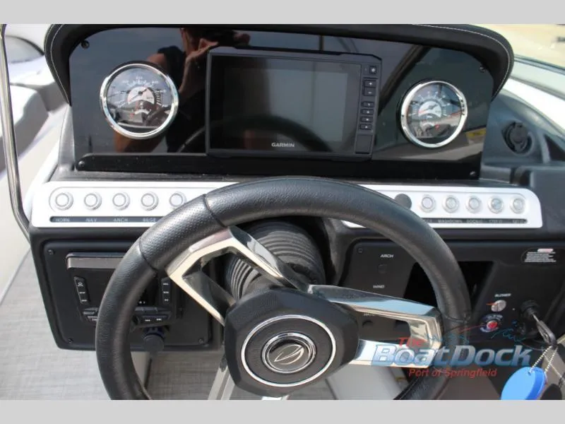 Slide: The Image of 2023 Crownline 240 SS boat dashboard with Garmin navigation system and steering wheel. - 10