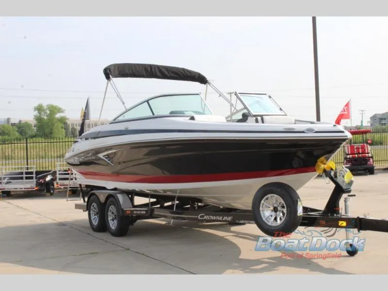 Slide: The Image of 2023 Crownline 240 SS boat on a trailer at The Boat Dock dealership. - 2
