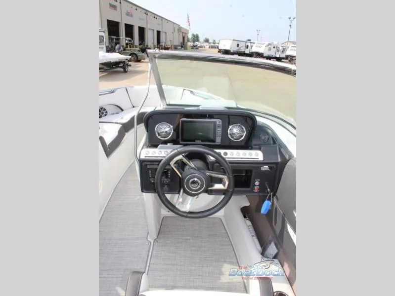 Slide: The Image of 2023 Crownline 240 SS boat dashboard with steering wheel and control panel. - 8