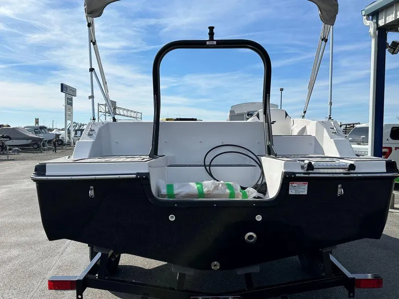 Slide: The Image of 2024 Starcraft SVX 191 OB boat rear view at a dealership. - 2