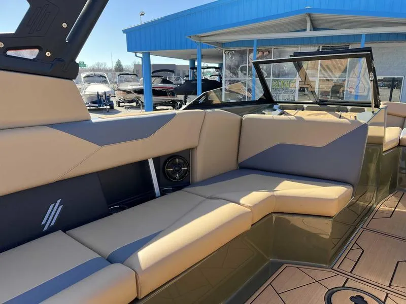 Slide: The Image of 2024 ATX Surf Boats 24 Type-S interior seating area with beige and gray upholstery. - 11