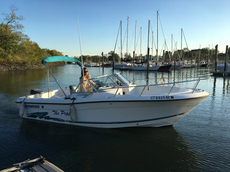 The Image of 1998 Stratos 2100 boat cruising in a marina with sailboats in the background. - 1