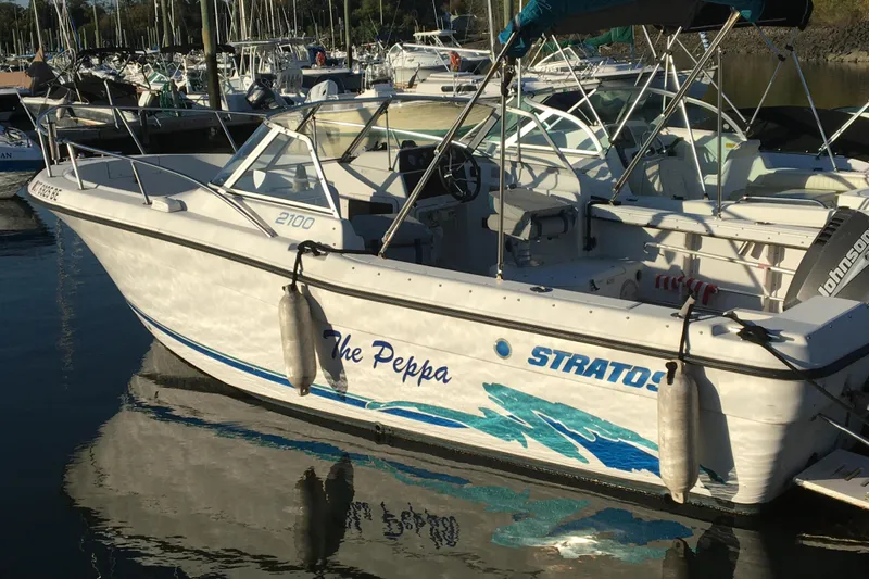 Slide: The Image of 1998 Stratos 2100 boat docked in a marina. - 10