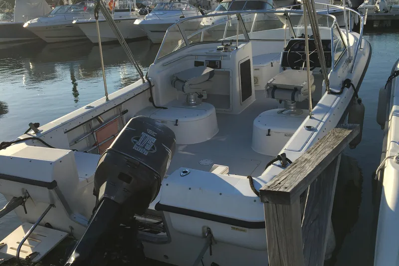 Slide: The Image of 1998 Stratos 2100 boat docked at a marina, featuring an outboard motor. - 13