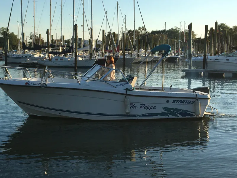 Slide: The Image of 1998 Stratos 2100 boat named The Peppa docked in a marina. - 5