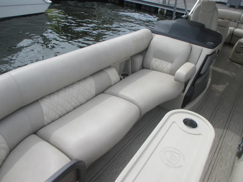 Slide: The Image of 2018 Premier 270 Intrigue RF pontoon boat with luxurious seating by the water. - 7