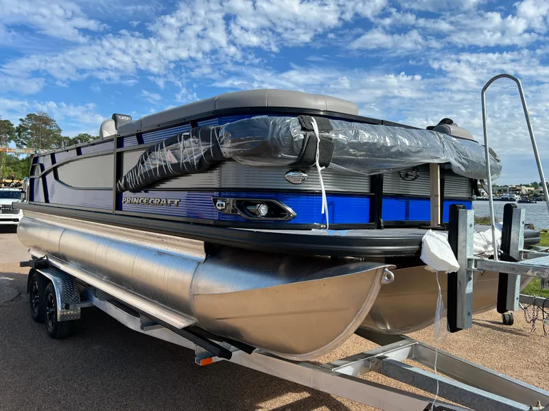 Slide: The Image of 2024 Princecraft Quorum 23 RL pontoon boat on a trailer by the water. - 3