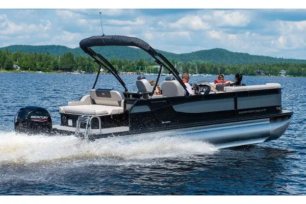 Slide: The Image of 2024 Princecraft Quorum 23 RL pontoon boat cruising on a scenic lake. - 7