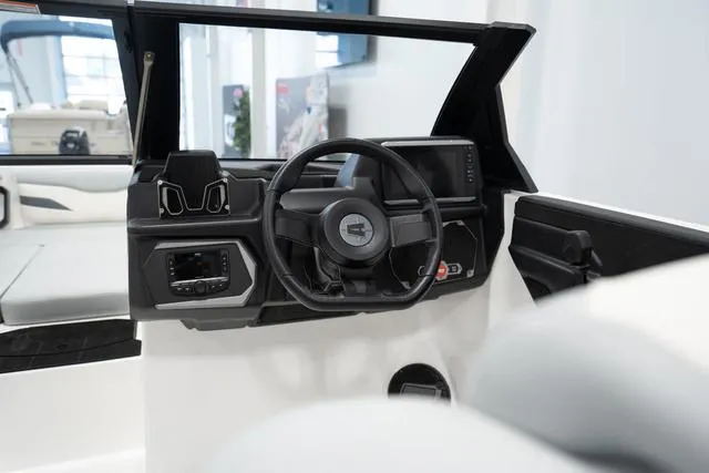 Slide: The Image of 2024 Axis Wake Research T220-R boat dashboard with steering wheel and control panel. - 6