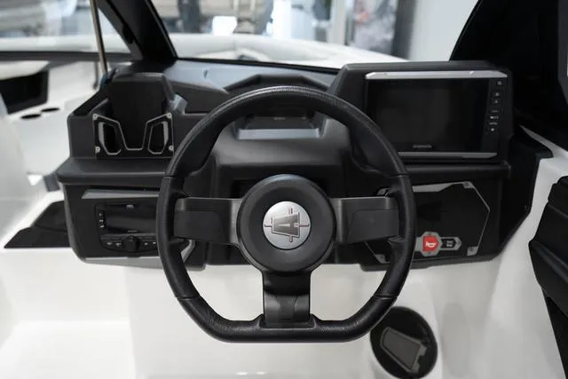 Slide: The Image of 2024 Axis Wake Research T220-R boat dashboard with steering wheel and touchscreen display. - 7